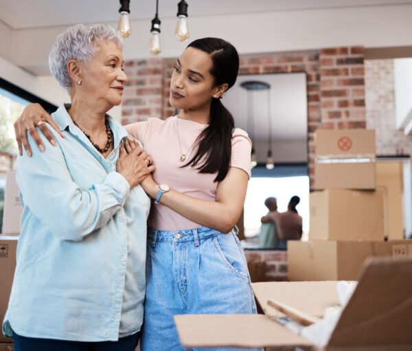 Senior woman packing up her belongings with her adult daughter in preparation for a move to assisted living.